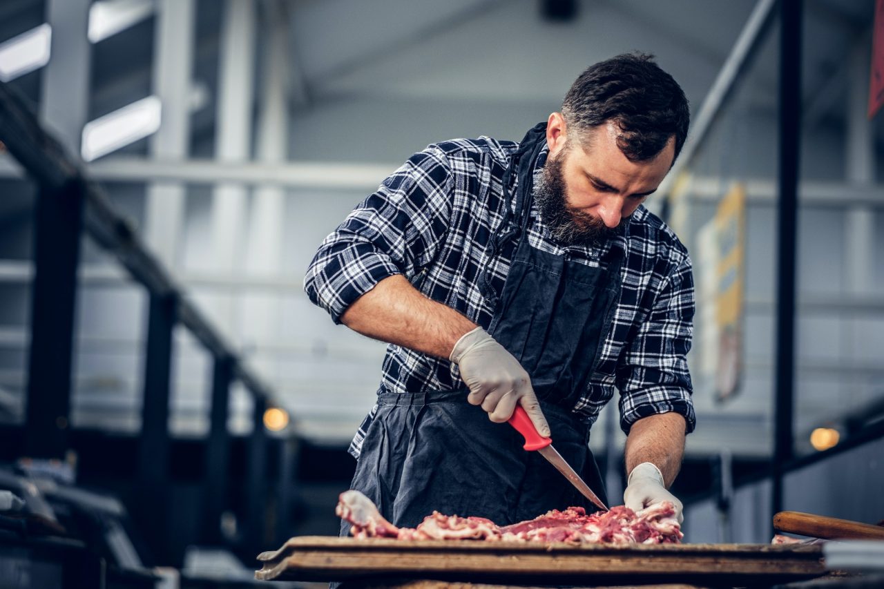 Bearded butcher cut fresh bacon meat .jpg
