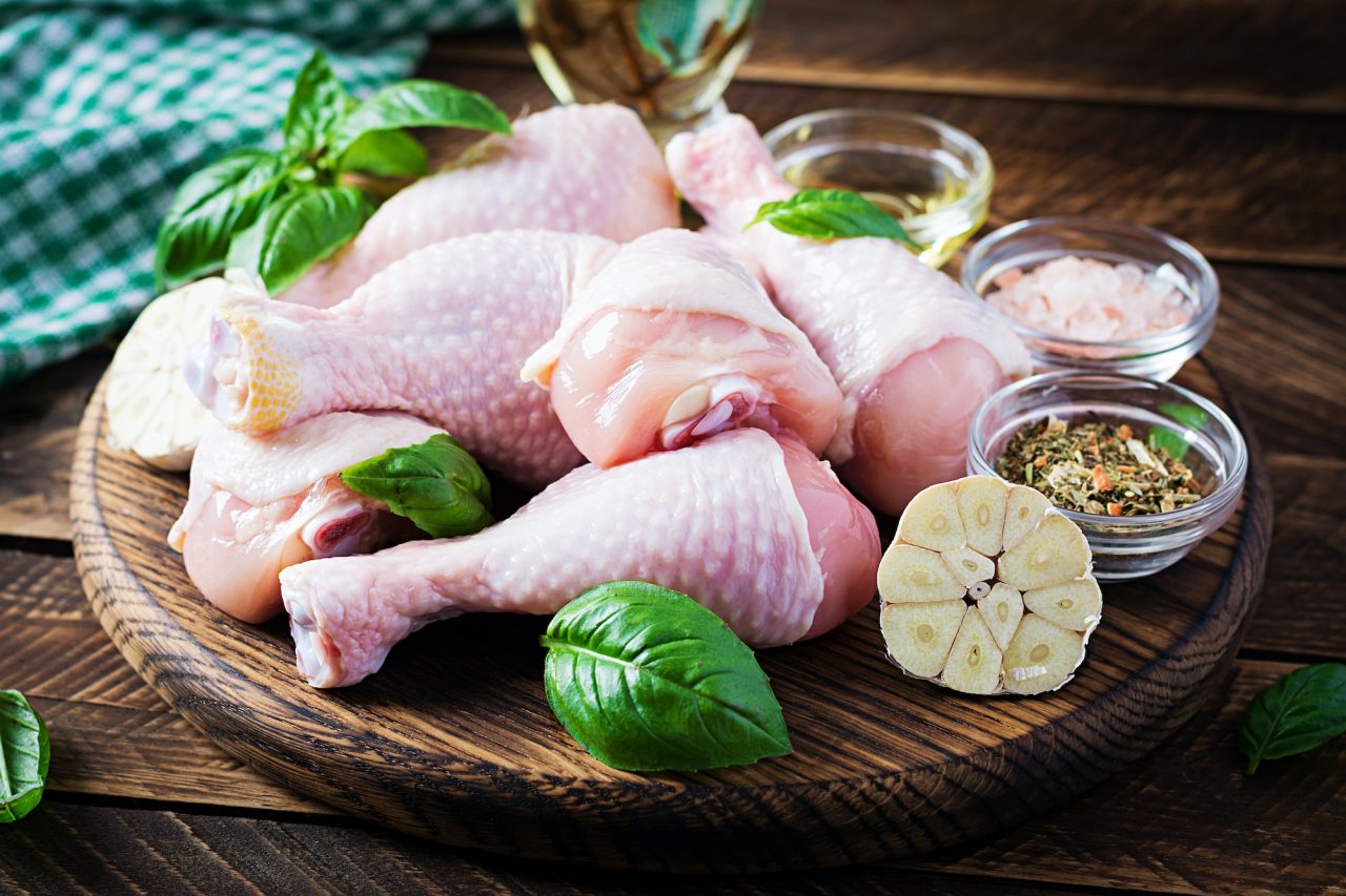 Raw chicken drumsticks with spices raw chicken legs with spices on a wooden background .jpg